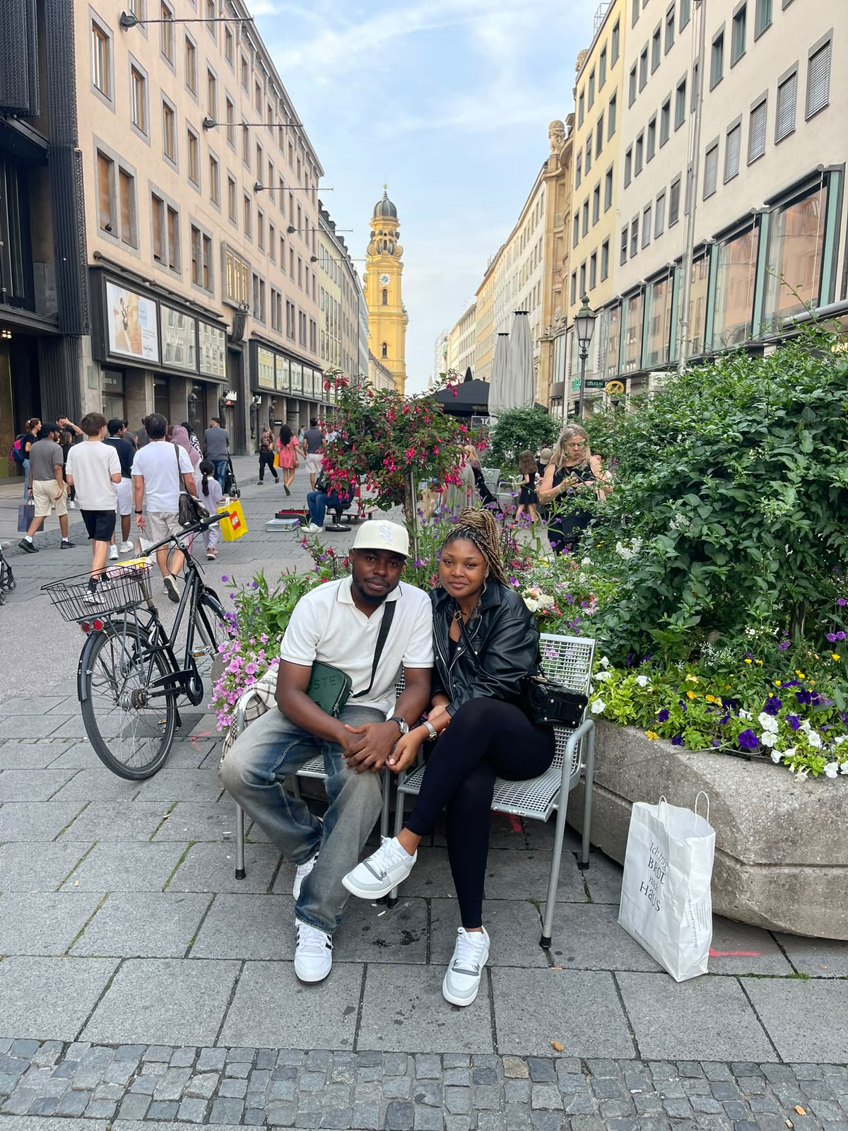 Nous deux assis au milieu des fleurs en ville